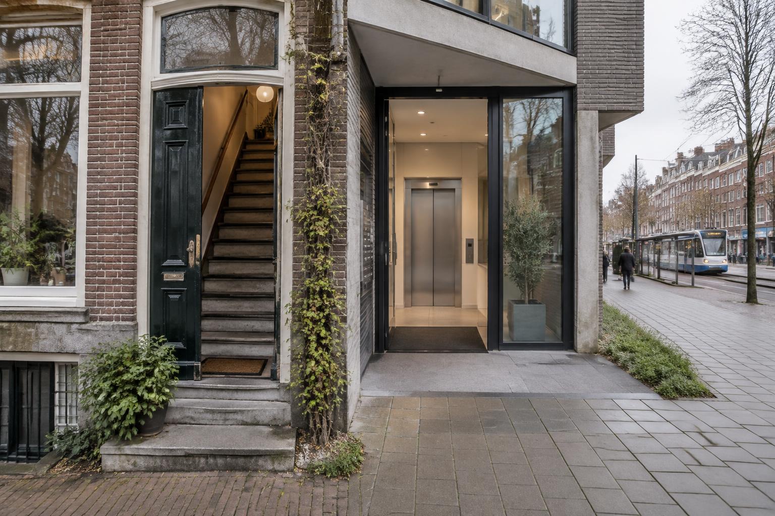 Oudere Amsterdamse appartementen met een trap naast een modern woongebouw met gelijkvloerse lifttoegang en openbaar vervoer in de straat.